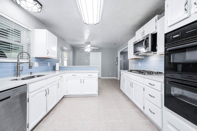 kitchen with kitchen peninsula, ceiling fan, stainless steel appliances, white cabinets, and sink