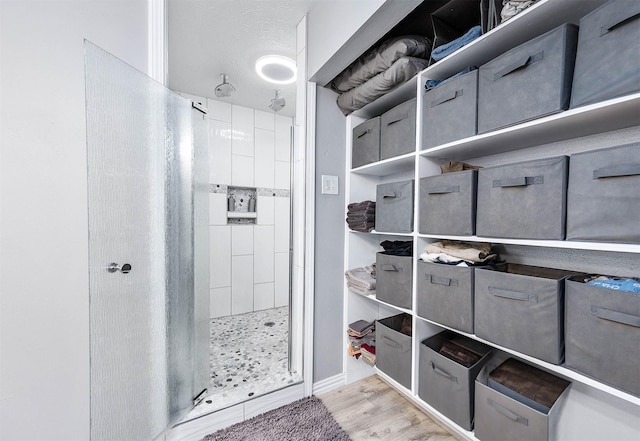 bathroom featuring a textured ceiling and a tile shower