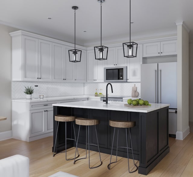 kitchen with an island with sink, hanging light fixtures, tasteful backsplash, and light hardwood / wood-style floors