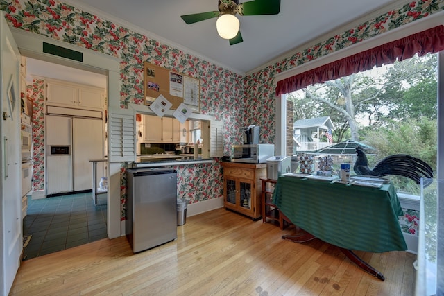 kitchen with light tile flooring, ceiling fan, oven, and paneled fridge