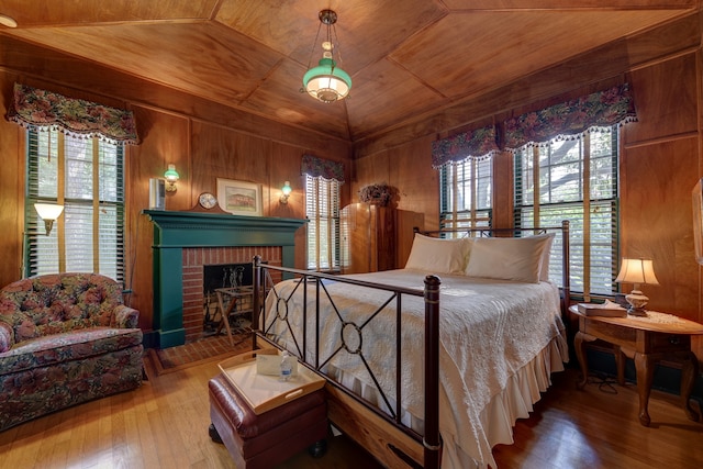 bedroom featuring wooden walls, multiple windows, wood ceiling, and hardwood / wood-style floors