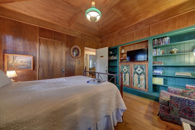 bedroom featuring wooden walls, wooden ceiling, and light hardwood / wood-style flooring