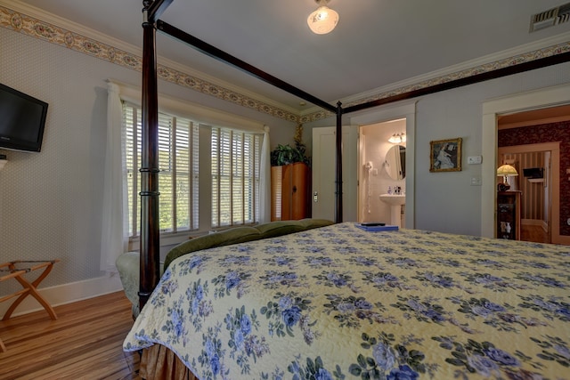 bedroom featuring ensuite bathroom, hardwood / wood-style floors, and crown molding