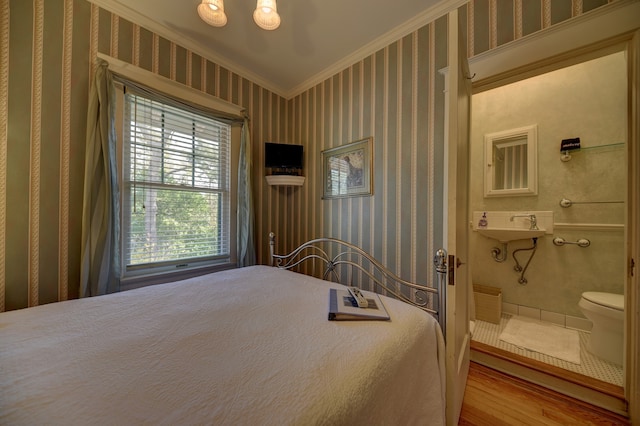 bedroom featuring ceiling fan with notable chandelier, sink, light tile floors, ensuite bath, and crown molding