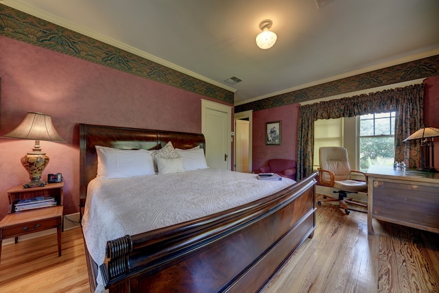 bedroom featuring ornamental molding and light hardwood / wood-style flooring