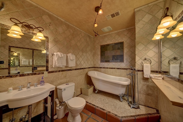 bathroom featuring sink, tile floors, toilet, and tile walls