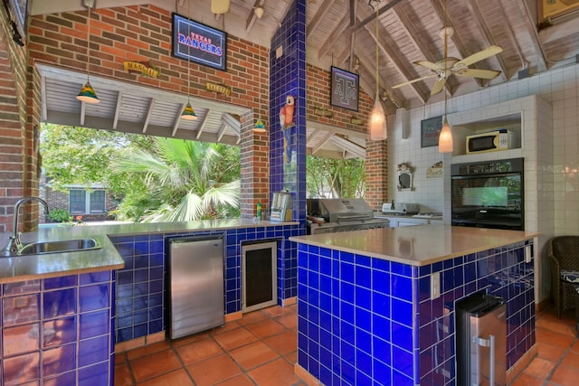 kitchen featuring a center island, refrigerator, black oven, beamed ceiling, and sink