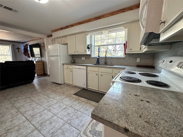 kitchen featuring white appliances, backsplash, light tile floors, sink, and white cabinetry