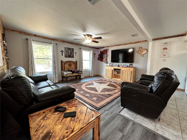 living room with a textured ceiling, ceiling fan, a wealth of natural light, and light hardwood / wood-style flooring