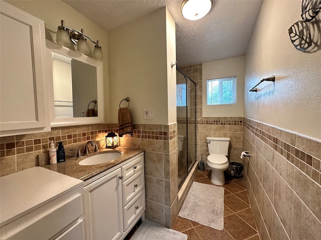 bathroom with tile walls, toilet, backsplash, tile floors, and vanity