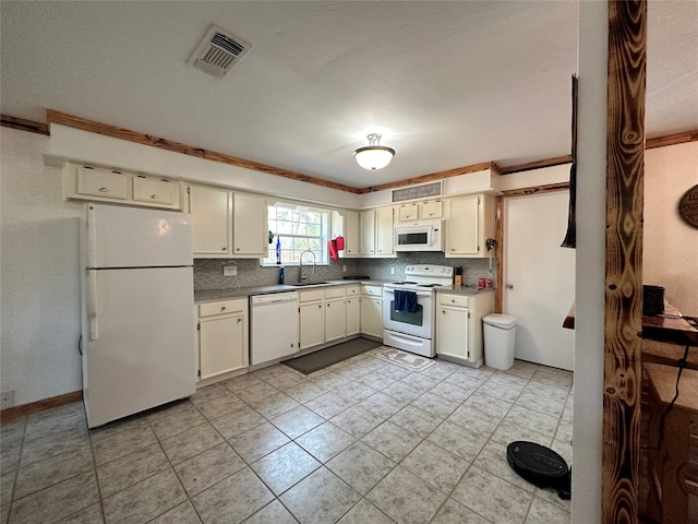 kitchen featuring white appliances, tasteful backsplash, cream cabinetry, and light tile floors