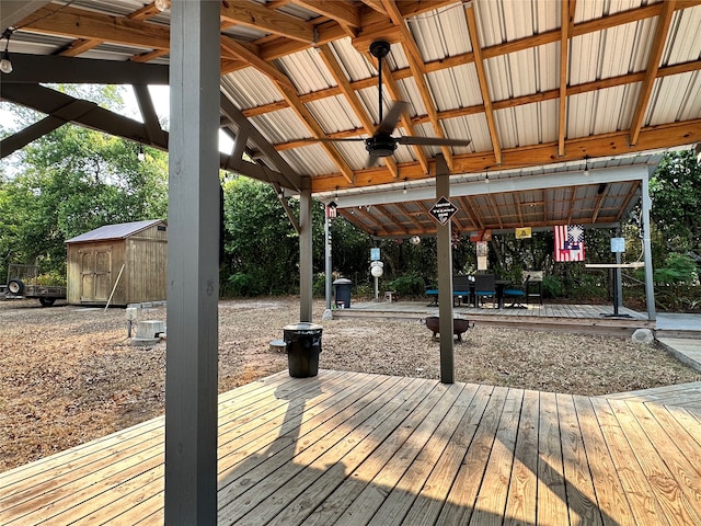 wooden terrace featuring ceiling fan and a storage unit