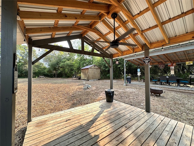 wooden deck with a shed and ceiling fan