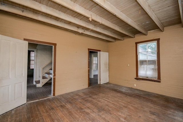 spare room featuring beamed ceiling, dark hardwood / wood-style flooring, and wooden ceiling