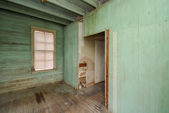 interior space with beamed ceiling, wooden walls, and hardwood / wood-style floors