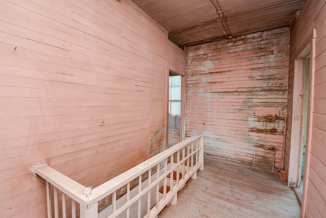 hall with wood walls and hardwood / wood-style floors