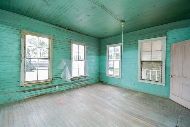 unfurnished room with wood ceiling, wood walls, and wood-type flooring