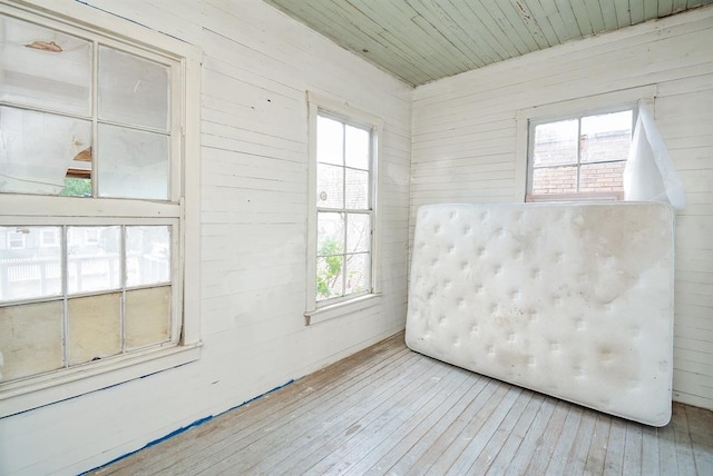 empty room featuring wood-type flooring, wood walls, and wood ceiling