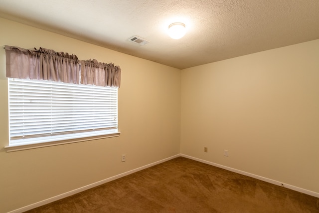 carpeted spare room featuring a textured ceiling