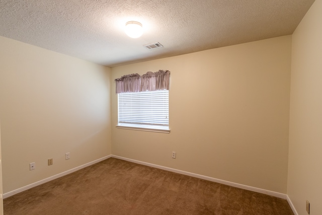 empty room featuring carpet and a textured ceiling