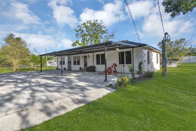 rear view of house with a carport and a yard