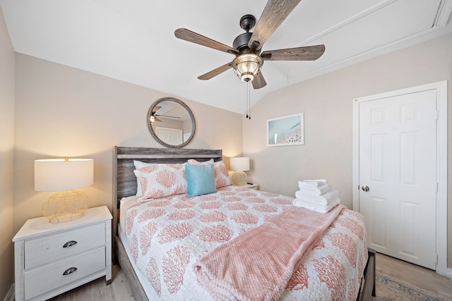 bedroom with ceiling fan, lofted ceiling, and light hardwood / wood-style floors