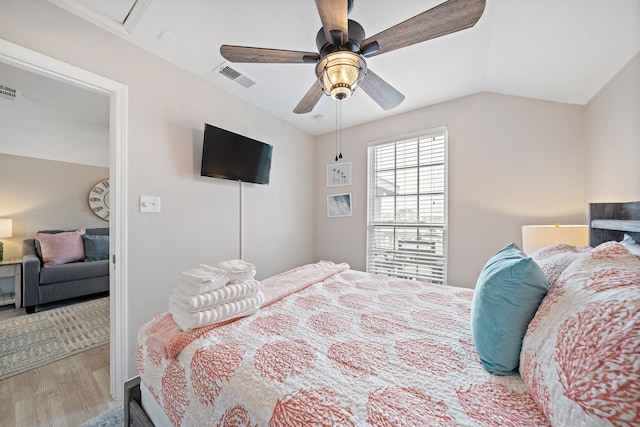 bedroom featuring light hardwood / wood-style floors, ceiling fan, and vaulted ceiling