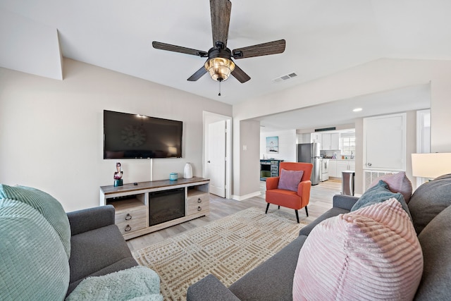 living room featuring light hardwood / wood-style floors and ceiling fan