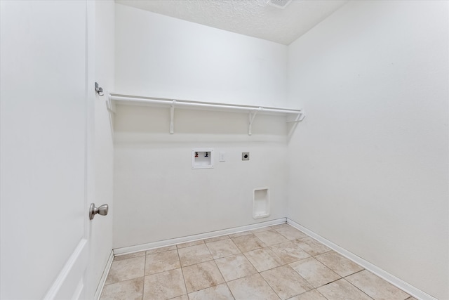 clothes washing area featuring electric dryer hookup, light tile patterned flooring, washer hookup, and a textured ceiling