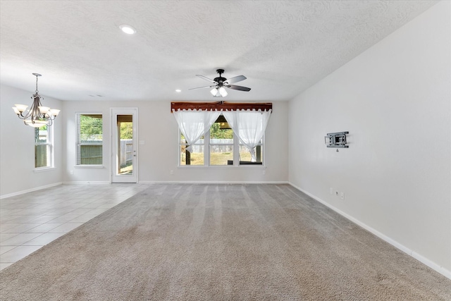 unfurnished living room with a textured ceiling, light tile patterned flooring, and ceiling fan with notable chandelier