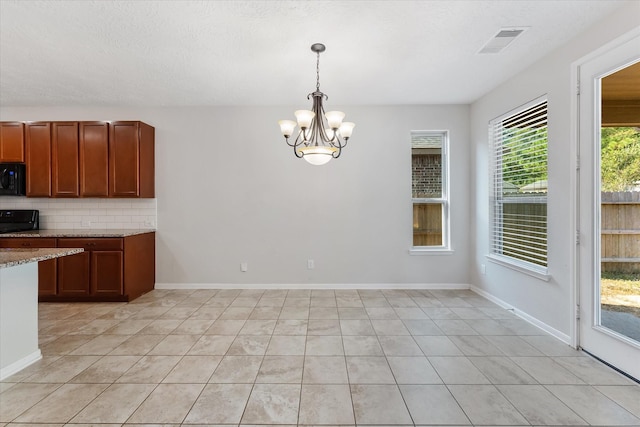 kitchen featuring tasteful backsplash, a notable chandelier, decorative light fixtures, light tile patterned floors, and black appliances