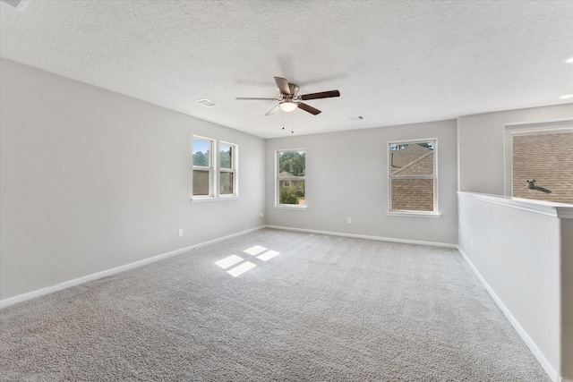 spare room with ceiling fan, light colored carpet, and a textured ceiling