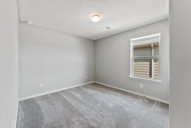 carpeted spare room with a textured ceiling