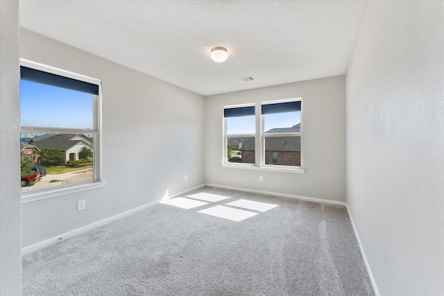 carpeted spare room with a textured ceiling