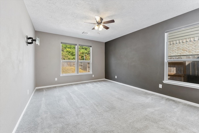 empty room with a textured ceiling, carpet floors, and ceiling fan