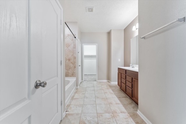 bathroom featuring tile patterned flooring, vanity, and a textured ceiling