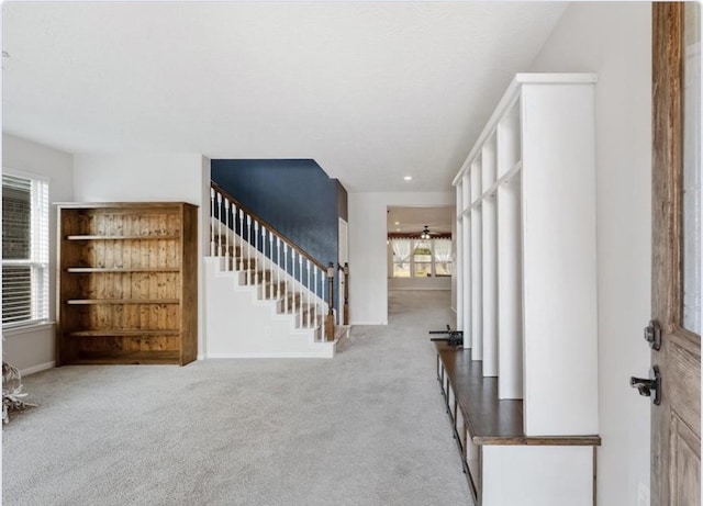 entryway with light carpet, a wealth of natural light, and ceiling fan