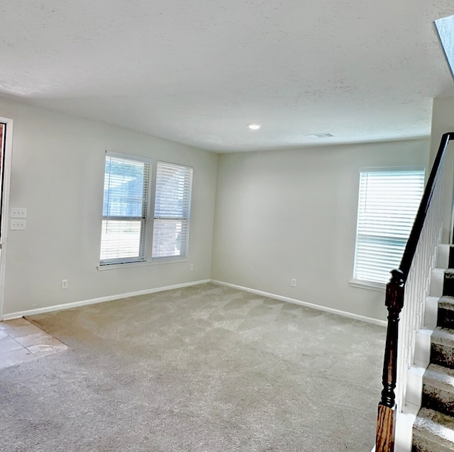 unfurnished room with a wealth of natural light and light colored carpet