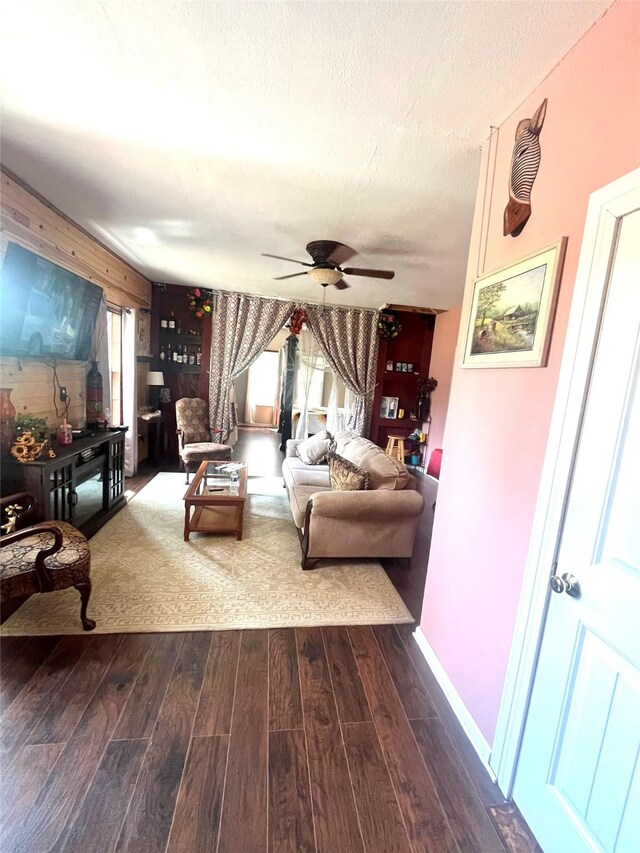 living room featuring a textured ceiling, a wealth of natural light, ceiling fan, and dark hardwood / wood-style flooring