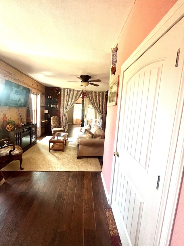 living room with a wealth of natural light, ceiling fan, and dark hardwood / wood-style flooring