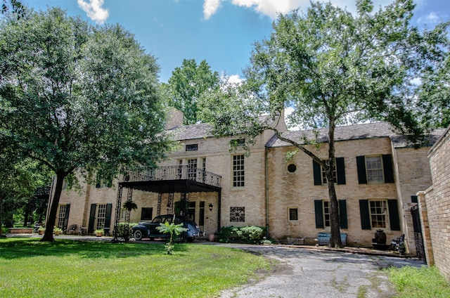 view of front of property with a front yard and a balcony