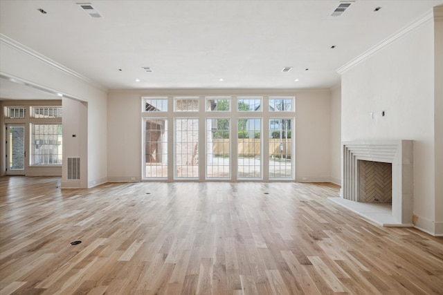 unfurnished living room featuring visible vents, a fireplace with raised hearth, and light wood-style flooring