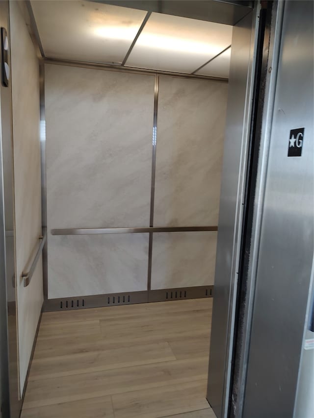 bathroom with elevator and wood-type flooring