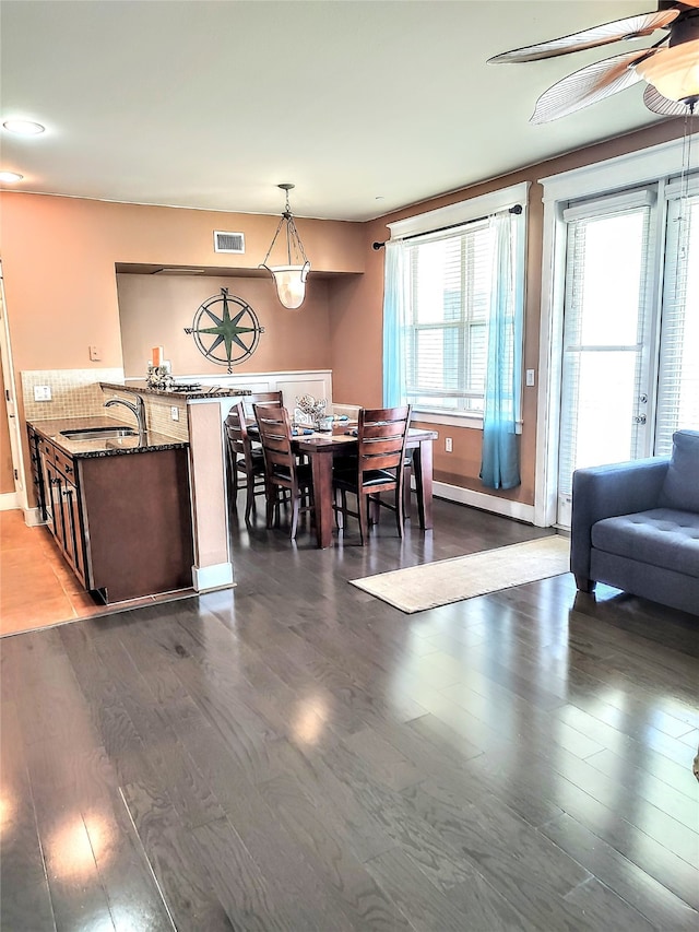 dining space featuring ceiling fan, sink, and wood-type flooring