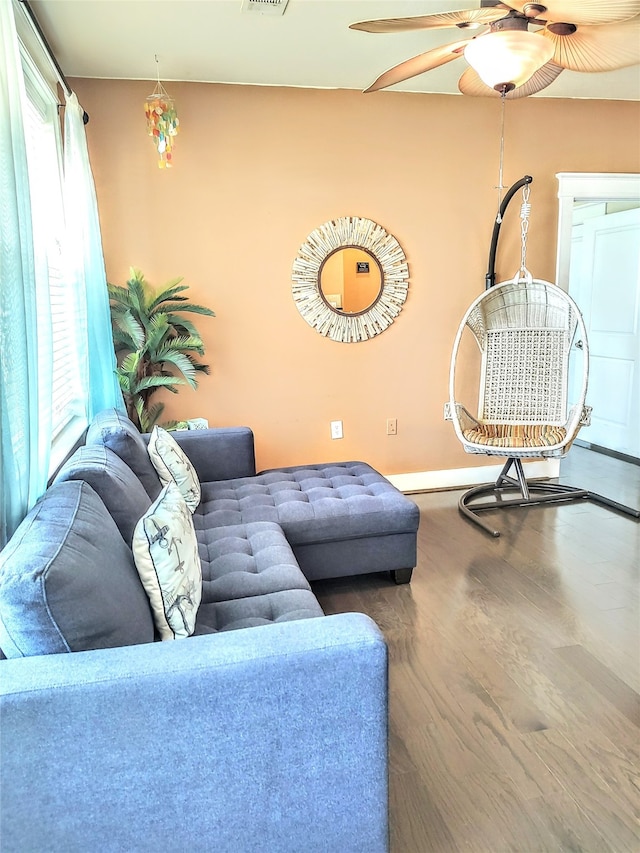 living room with ceiling fan, dark wood-type flooring, and a healthy amount of sunlight