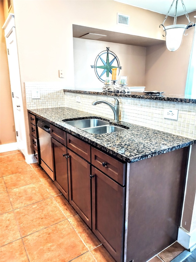 kitchen with backsplash, sink, dark stone countertops, light tile floors, and dishwasher