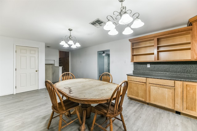 dining space featuring an inviting chandelier and light wood-type flooring