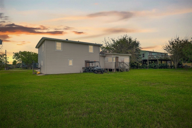 back house at dusk with a lawn