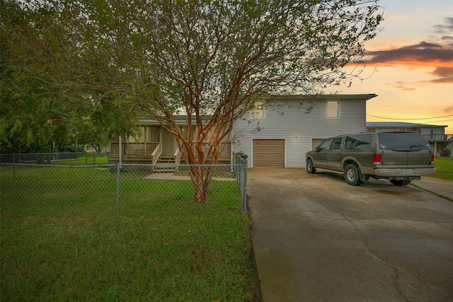 view of front of property with a garage and a lawn