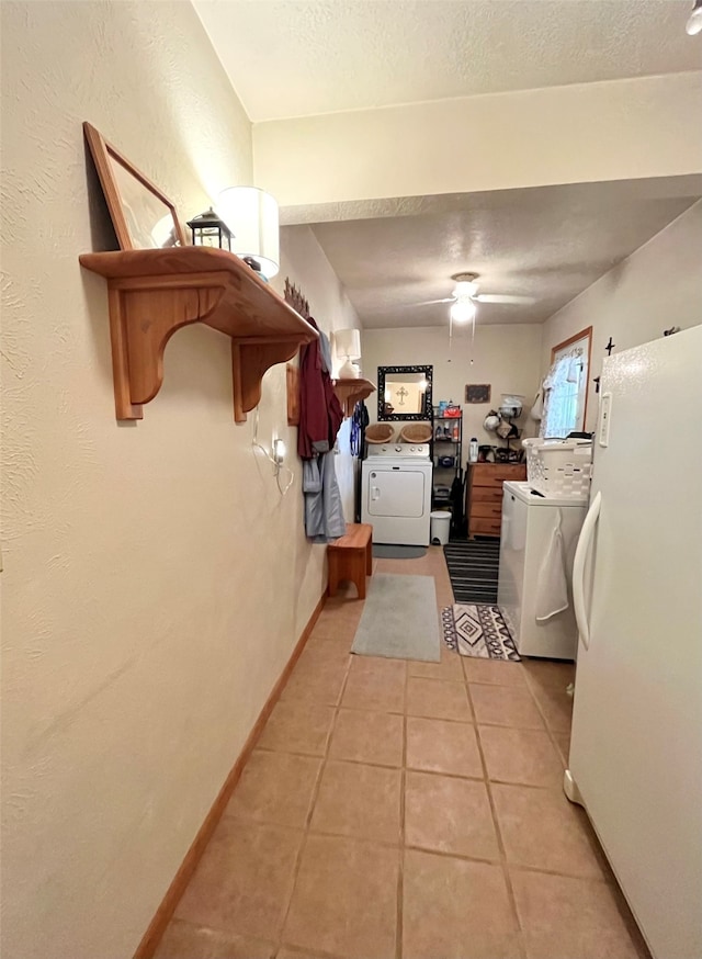 interior space with washer / dryer, a textured ceiling, and light tile patterned floors